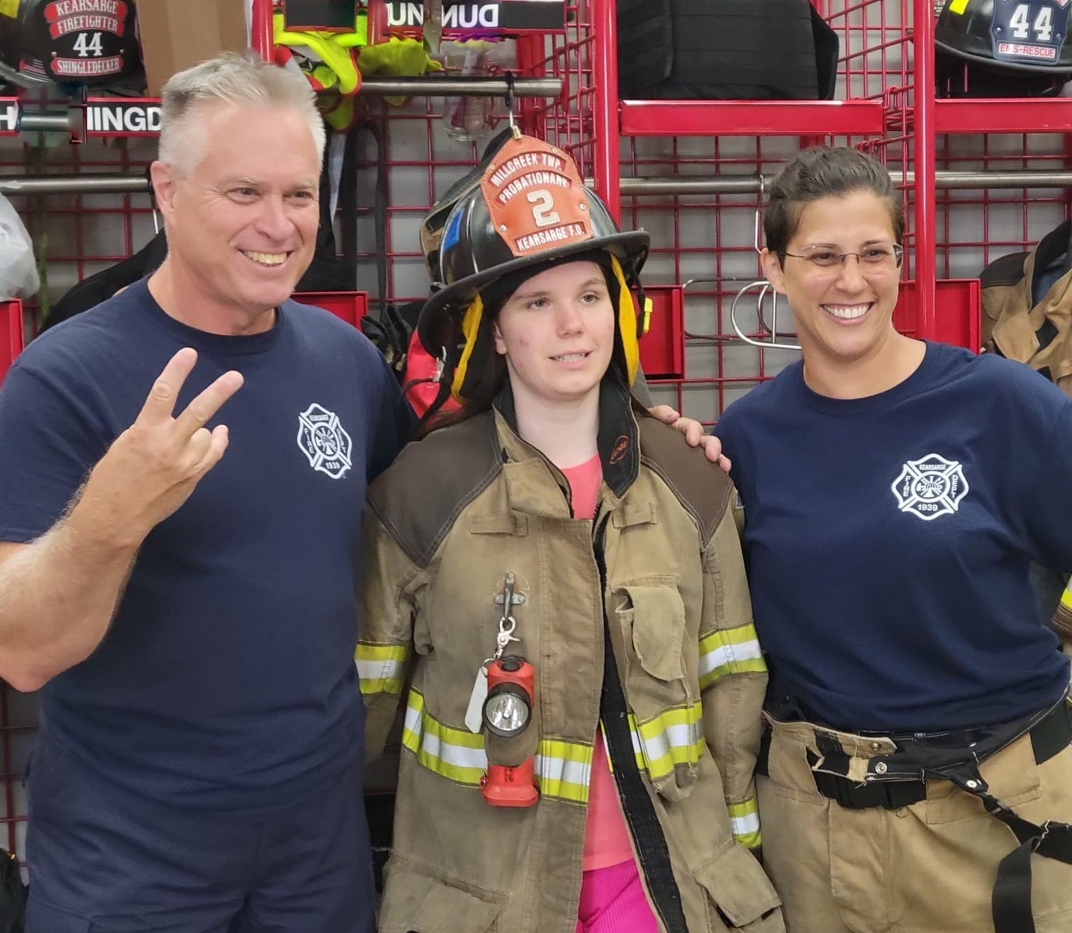 Two Camp Shamrock participants taking a picture with a firefighter