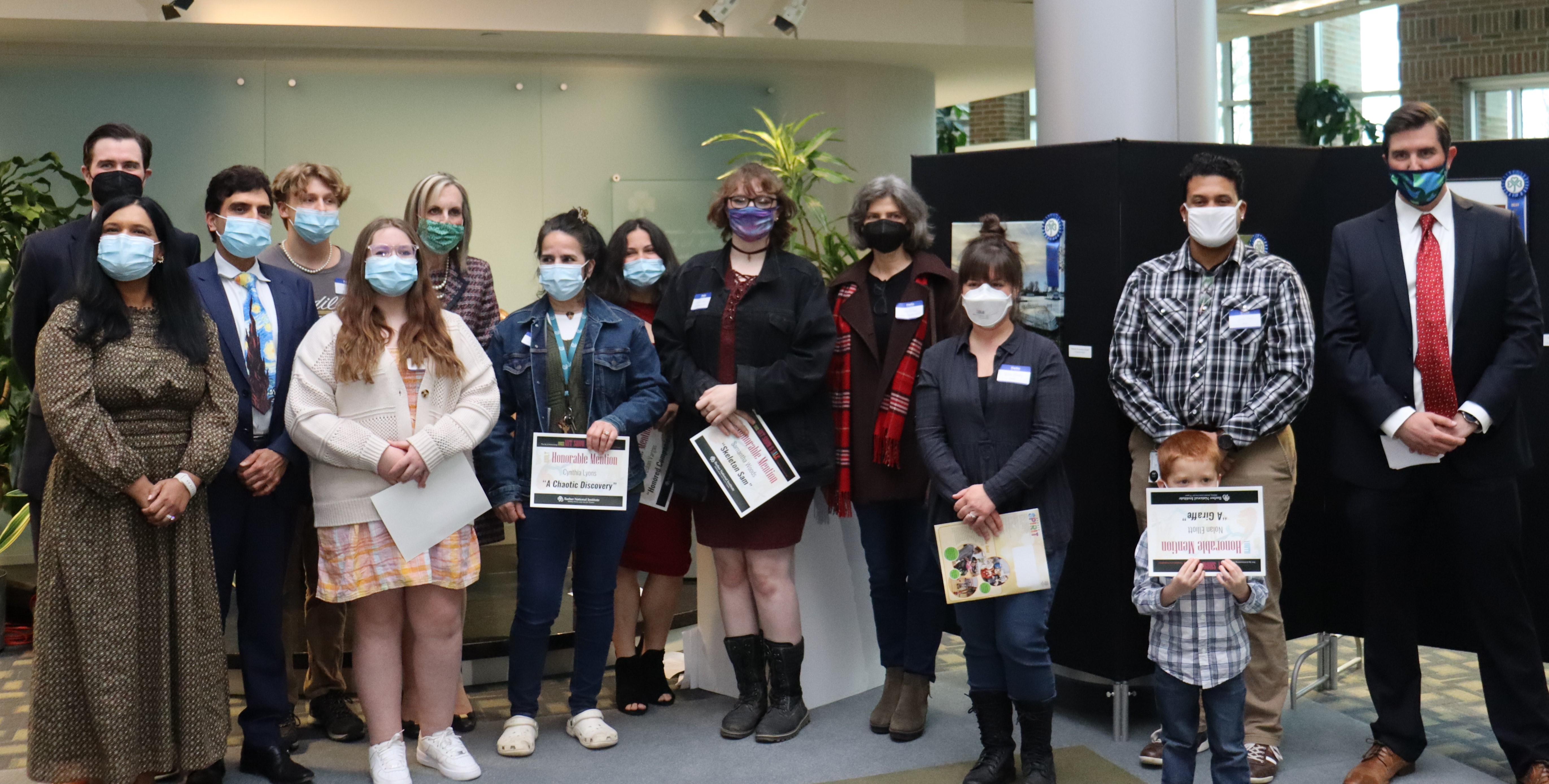 A group of people holding certificates for the 2022 Art Show