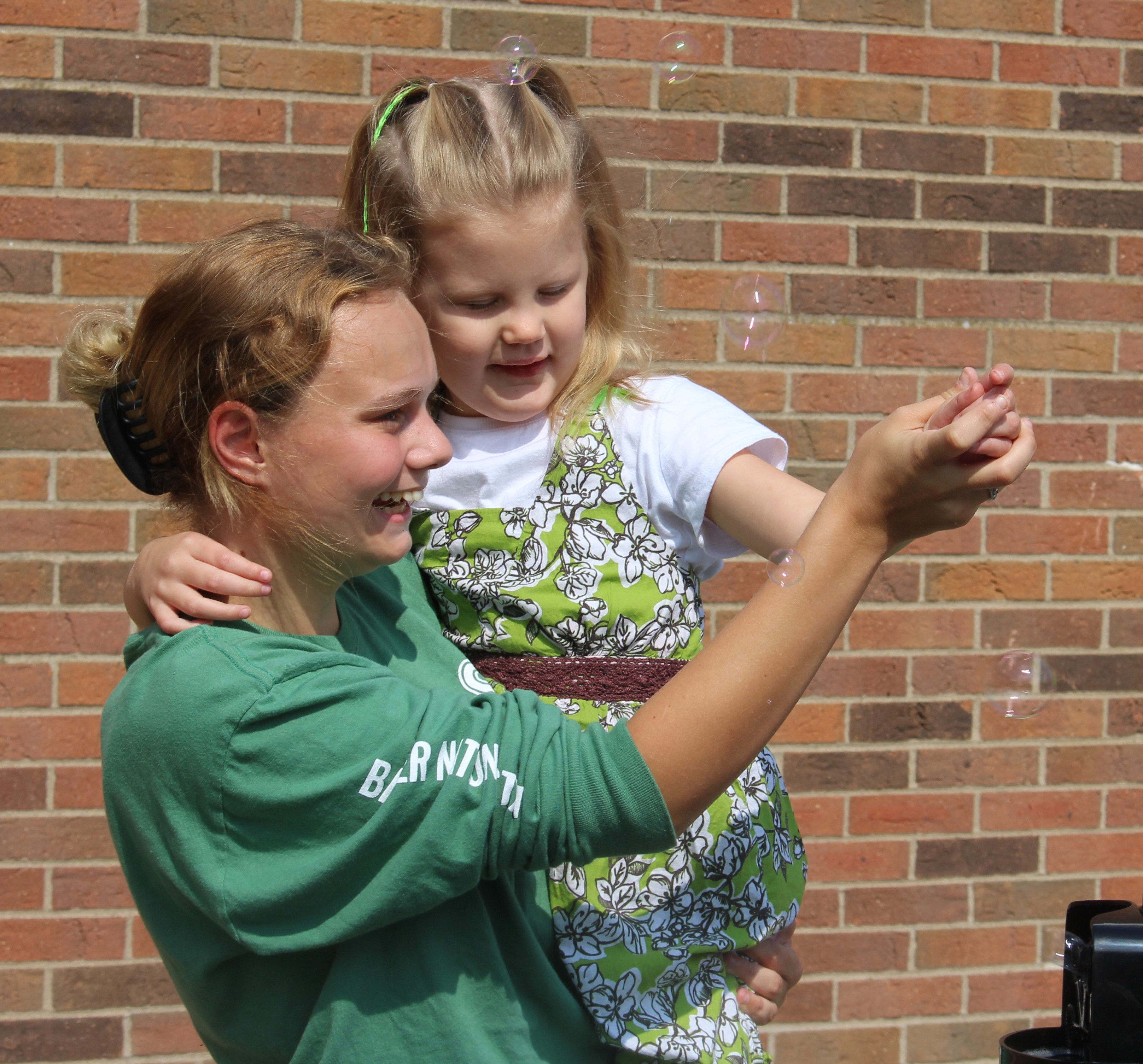 A young woman holding an elementary school girl